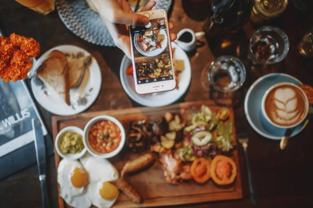 L'écran d'un portable qui prend la photo d'une table pleine de nourriture