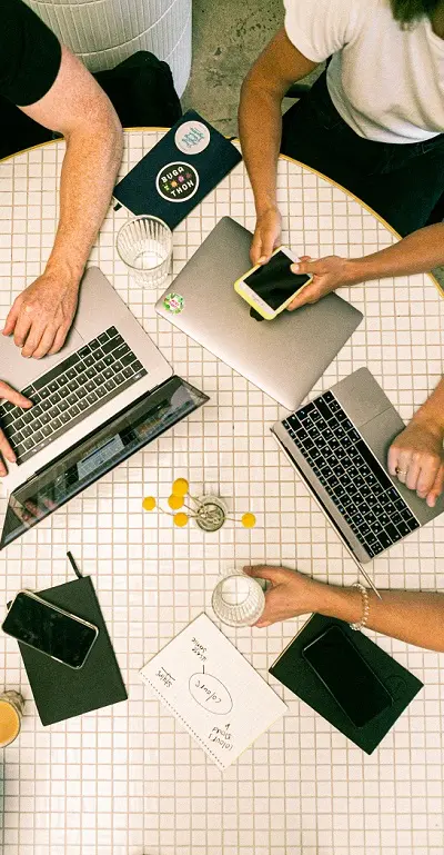 Des personnes autour d'une table qui travaillent avec des ordinateurs