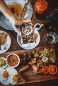 L'écran d'un portable qui  prend la photo d'une table pleine de nourriture