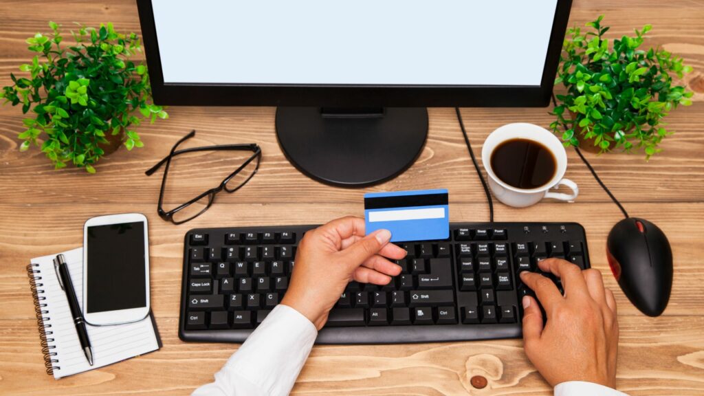 Lutter contre le no-show avec le paiement en ligne avec une carte bancaire devant un ordinateur.